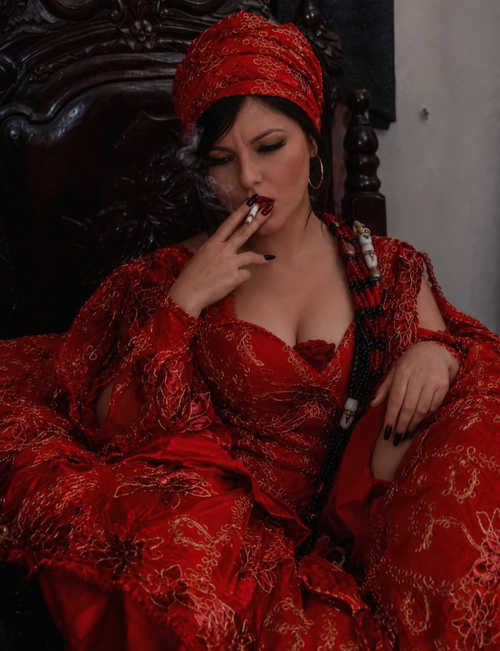 Mãe Kamilla de Iansã de vermelho e dourado, na energia da cigana, durante um trabalho espiritual