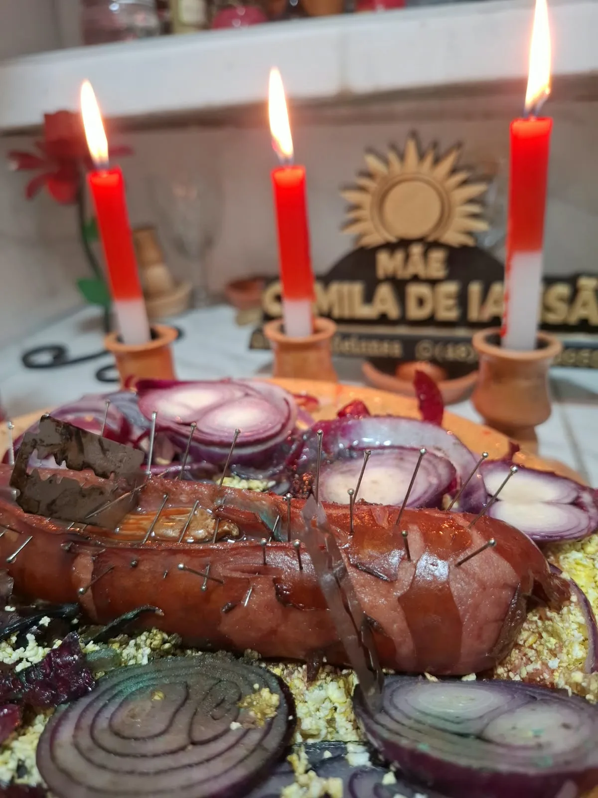 Preparo espiritual com velas vermelhas acesas sobre uma mesa de trabalho